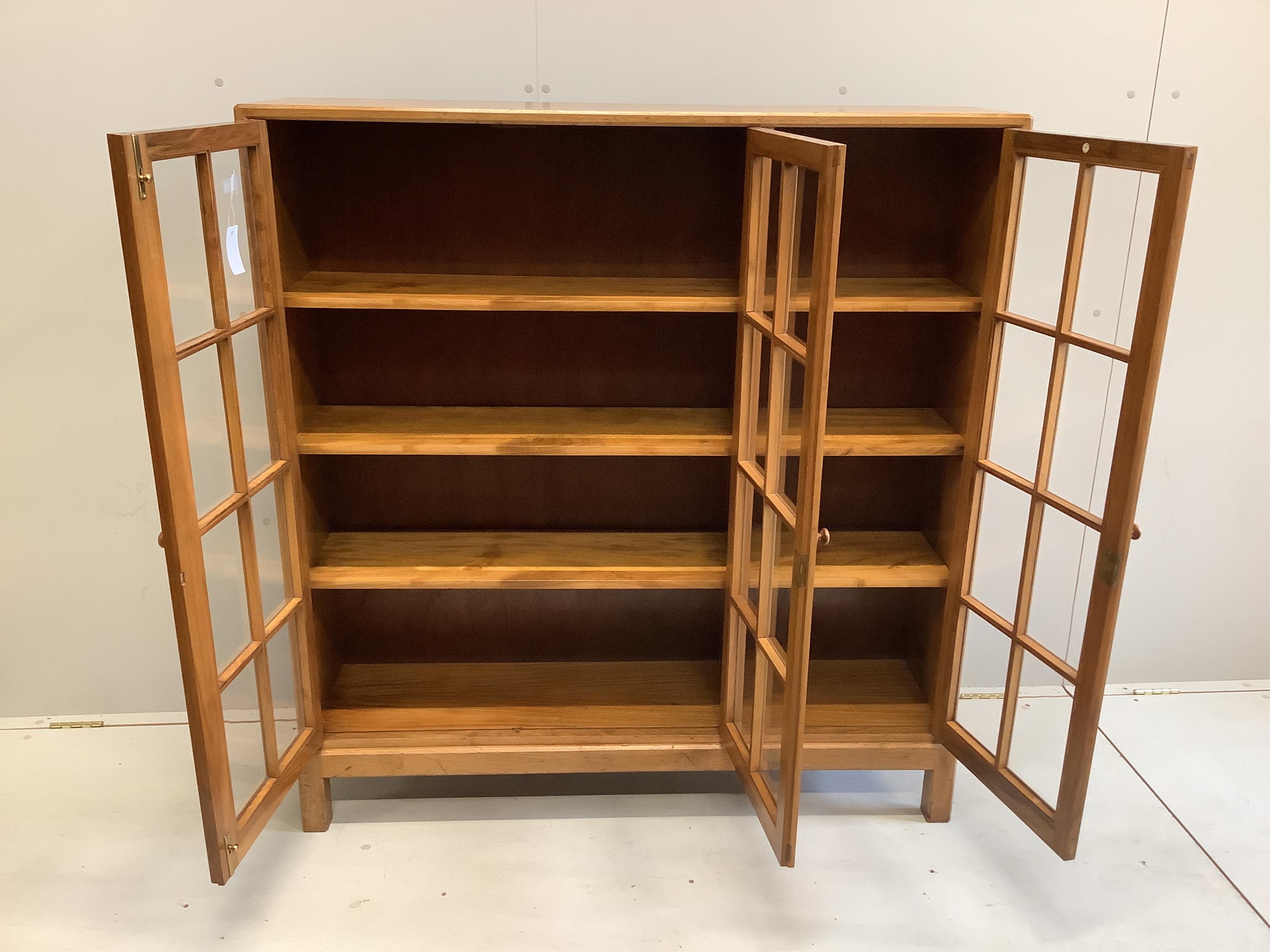An early 20th century Heal & Son, London glazed walnut three door bookcase, width 122cm, depth 29cm, height 130cm
